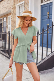 Light green peplum blouse with flutter sleeves, V-neck, buttons, and ruffled hem.