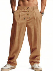 Men's loose fit drawstring pants in earthy yellow with button fly and pleated front.