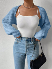 Light blue acrylic knit bolero shrug with long sleeves, worn over a white camisole and jeans.