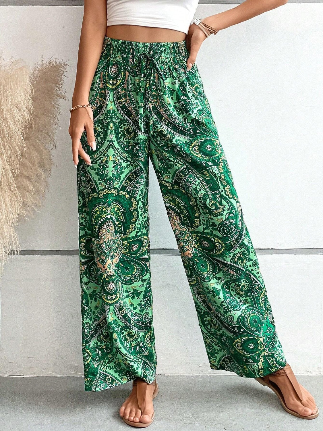 Paisley palazzo trousers in dark green with a drawstring waist and wide legs.