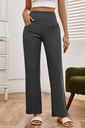 High-waisted flare leg trousers in dark gray with pockets, styled casually.