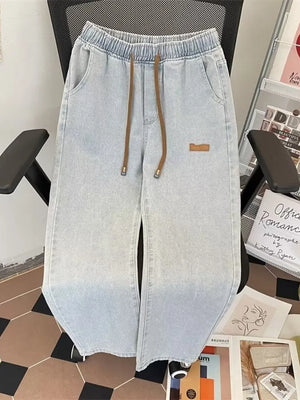 Light blue wide-leg jeans with drawstring waist and subtle ombre wash.