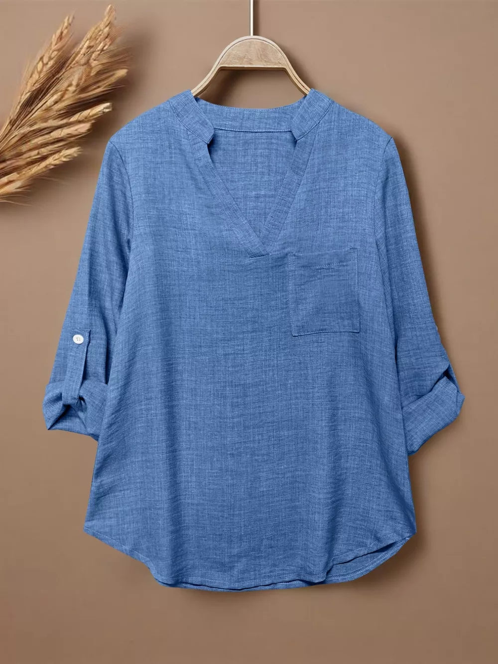 Blue textured maternity shirt with notched V-neck, chest pocket, and roll-tab sleeves.
