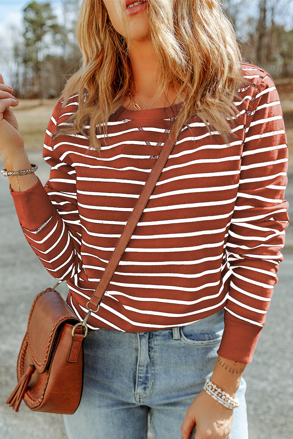 Nautical stripe crewneck sweatshirt in red orange with white stripes, crew neckline, and long sleeves.