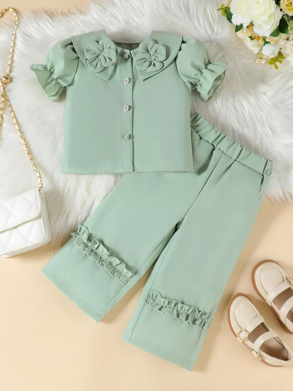 Green toddler set with floral collar, ruffle sleeves, and ruffle hem pants.