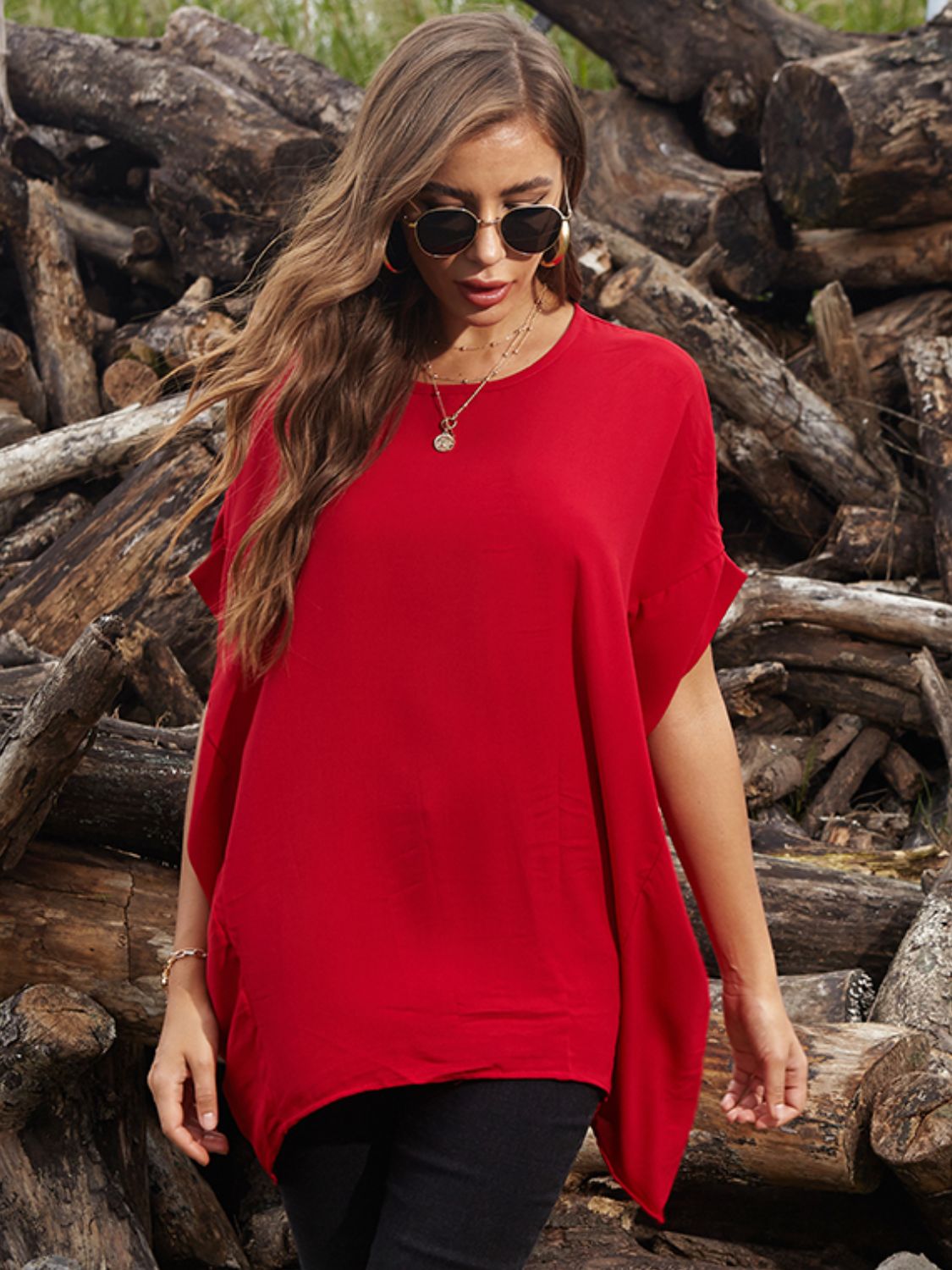 Scarlet red blouse with asymmetrical draped sleeves and a relaxed fit.