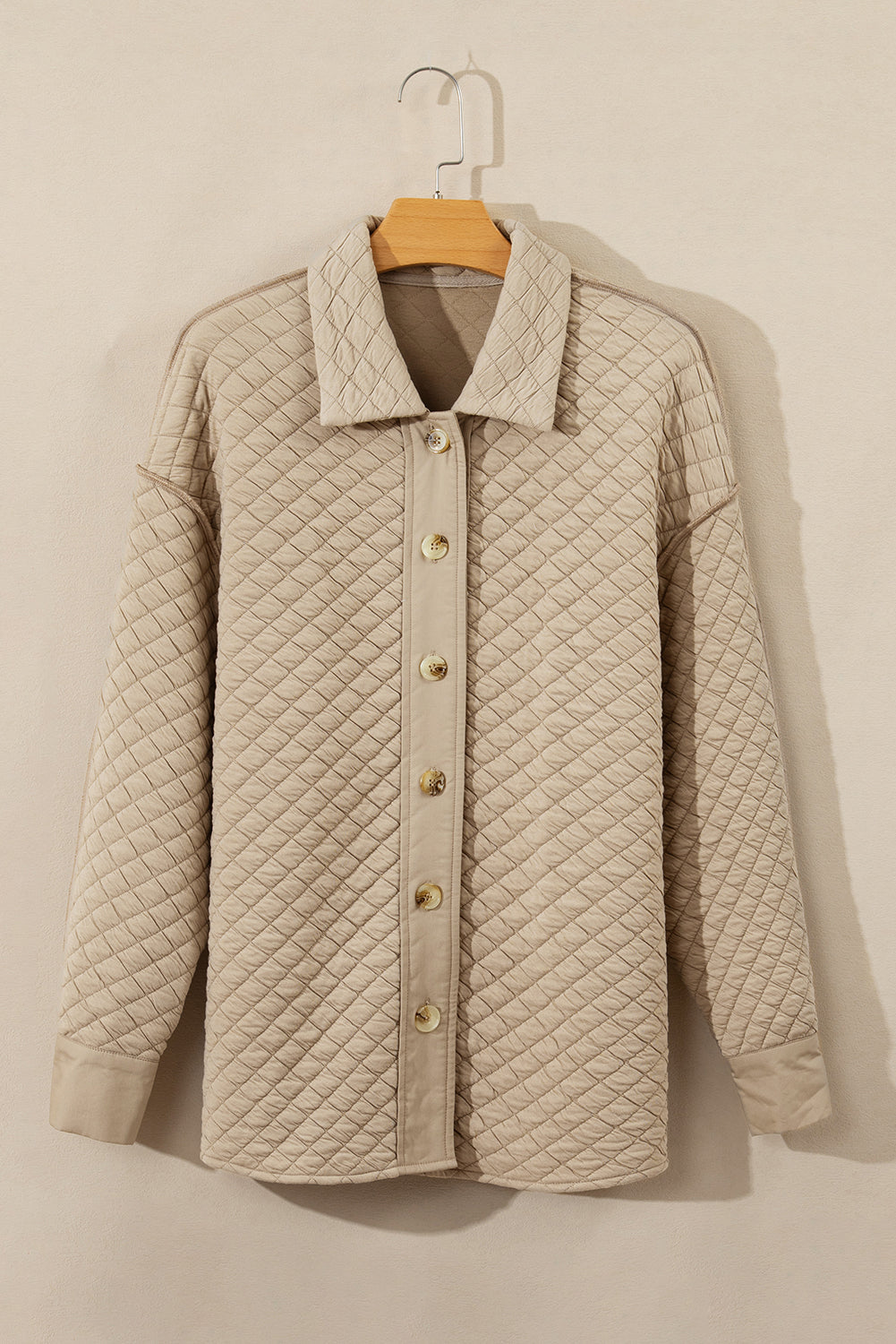 Beige diamond quilted oversized button-up jacket with a collared neckline.