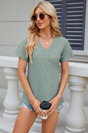 Light green eyelet wrap V-neck top with short sleeves.
