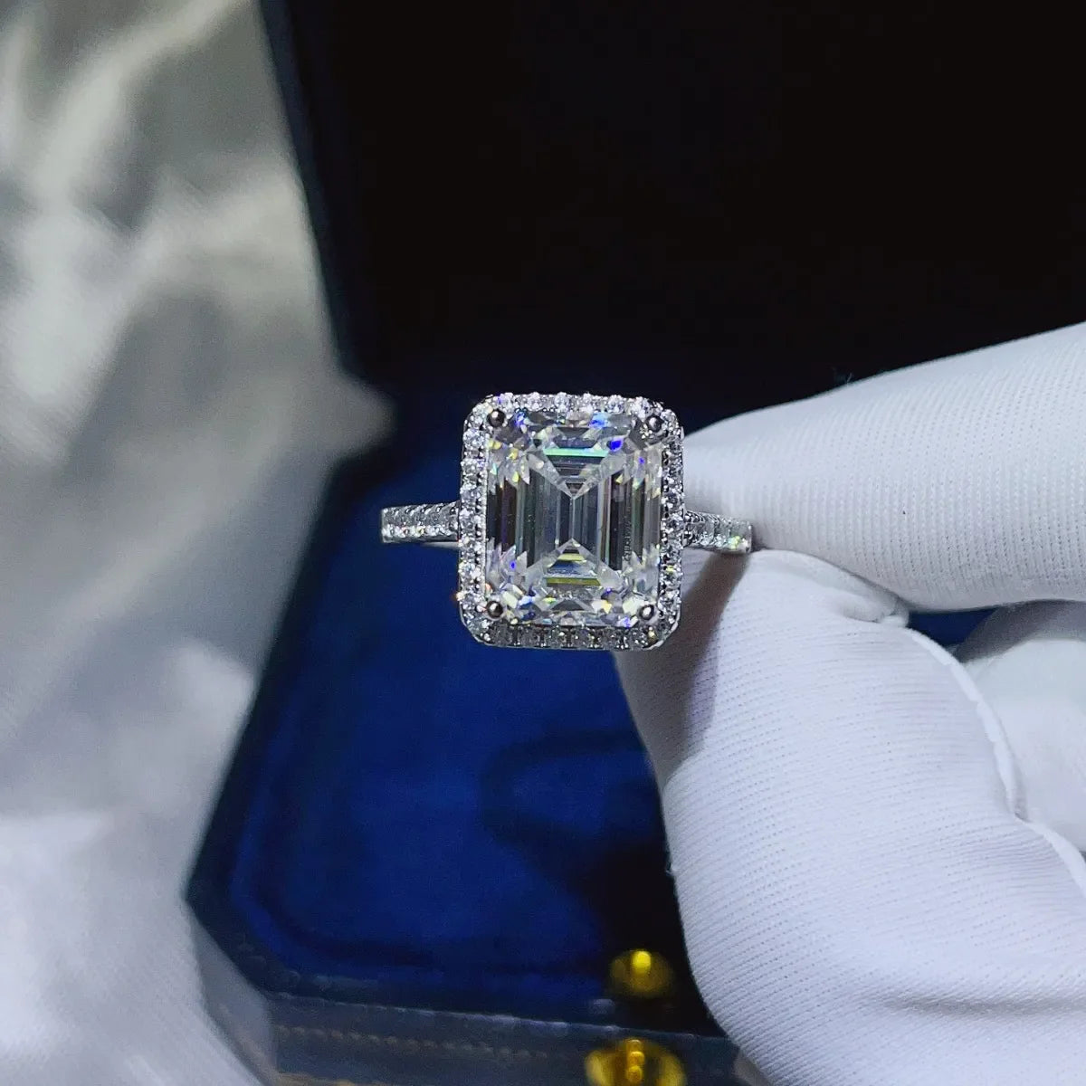 Emerald cut moissanite halo ring in sterling silver with pave band.