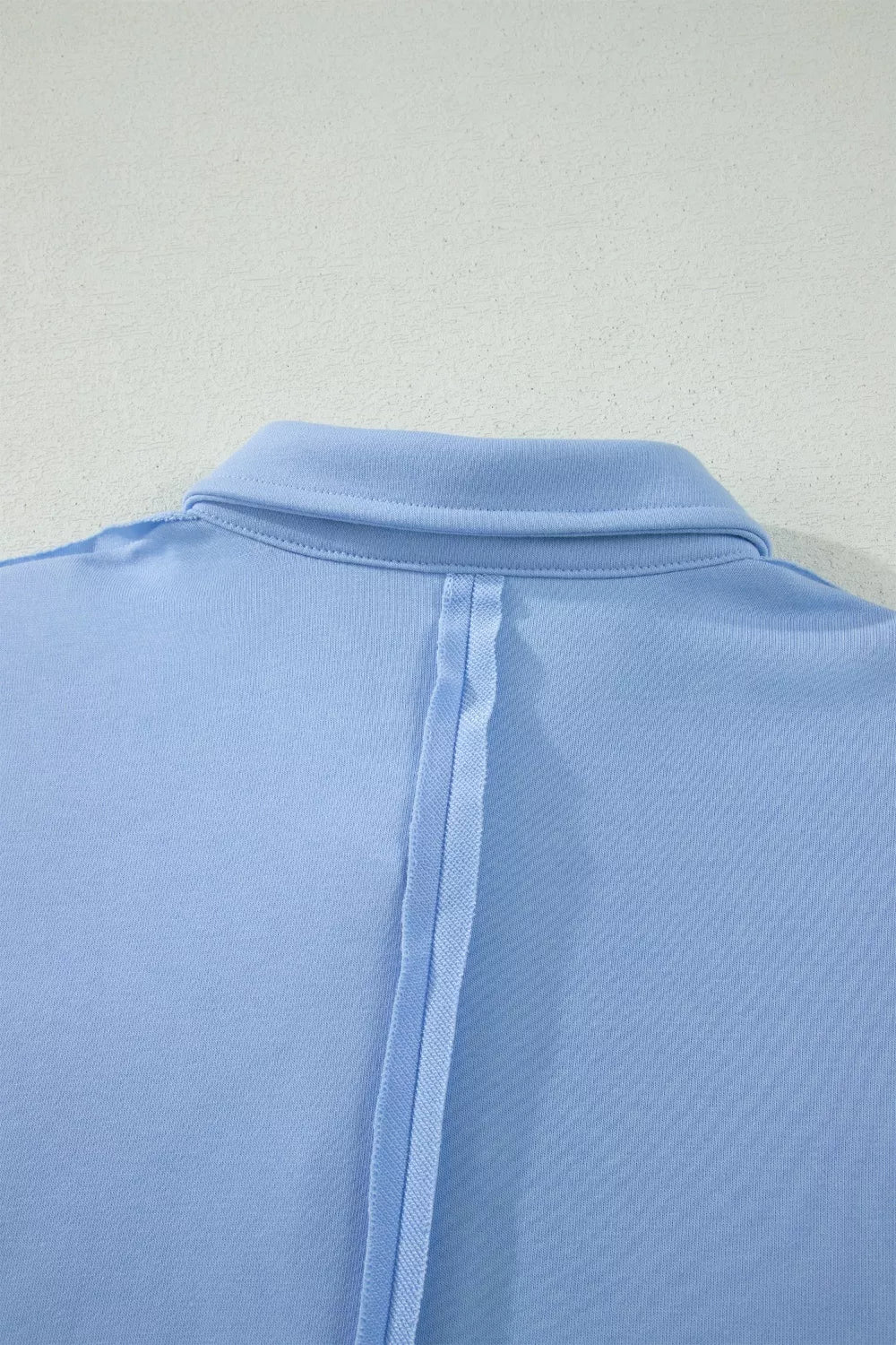Light blue sleeveless polo shirt with a buttoned collar and vertical seam detail.