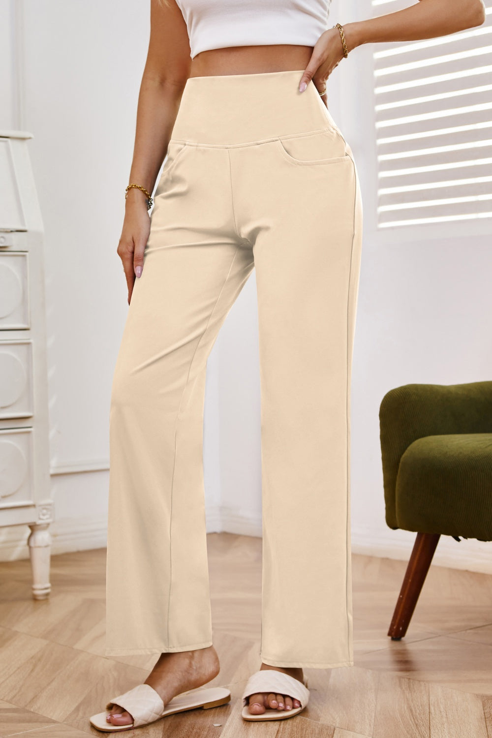 High-waisted flare leg trousers in tan with pockets, styled casually.