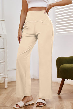 High-waisted flare leg trousers in tan with pockets, styled casually.