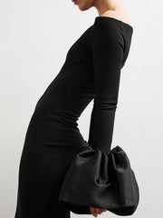 Black off-shoulder maxi dress with dramatic gathered sleeves.