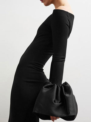 Black off-shoulder maxi dress with dramatic gathered sleeves.