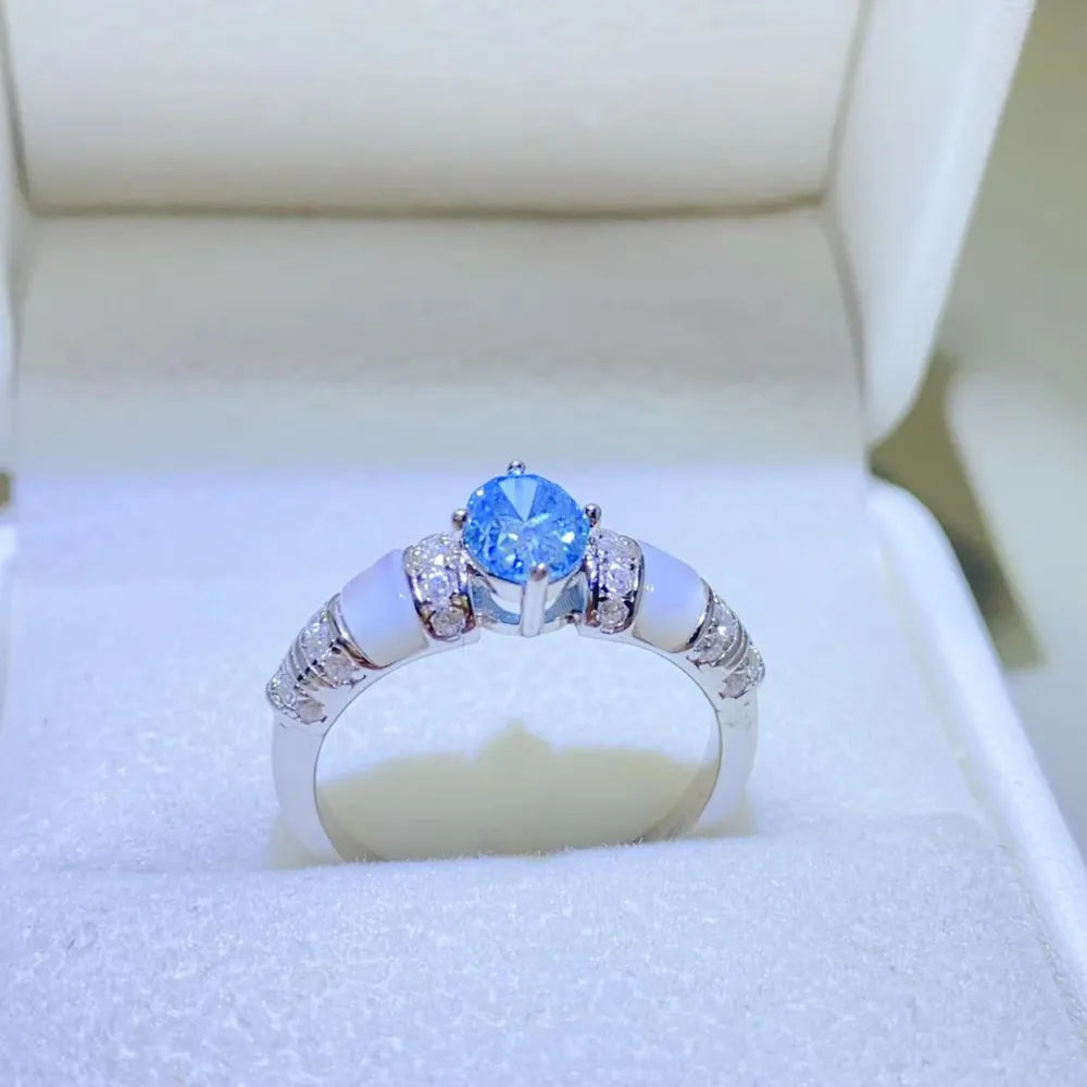 Silver ring with blue oval moissanite and mother-of-pearl accents