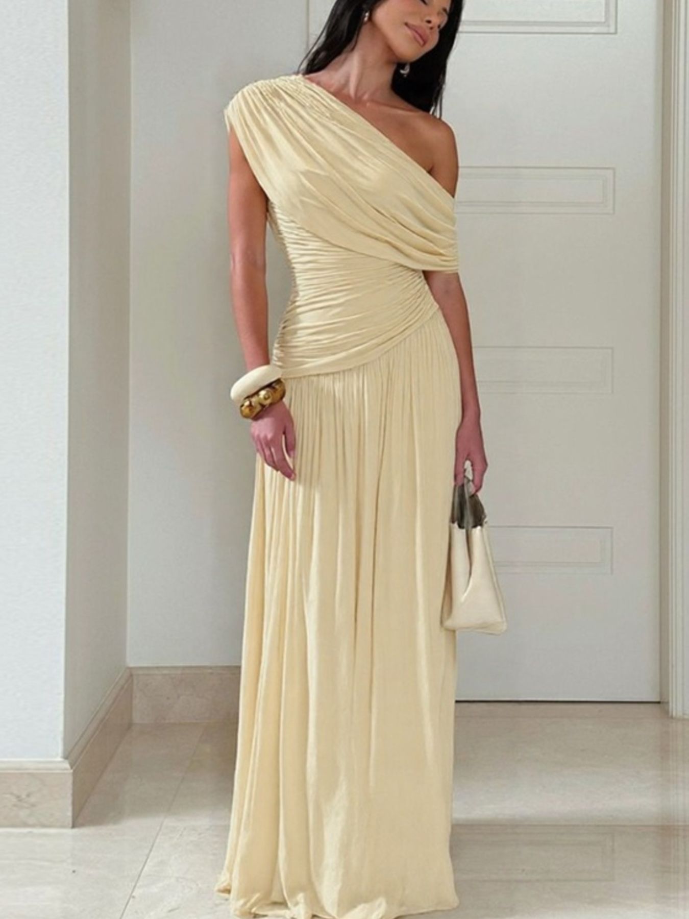 Elegant beige one-shoulder maxi dress with draped bodice and ruching.