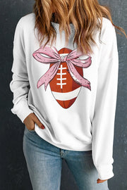 White sweatshirt with football graphic and pink polka dot bow detail.