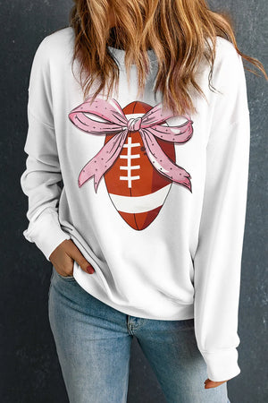 White sweatshirt with football graphic and pink polka dot bow detail.