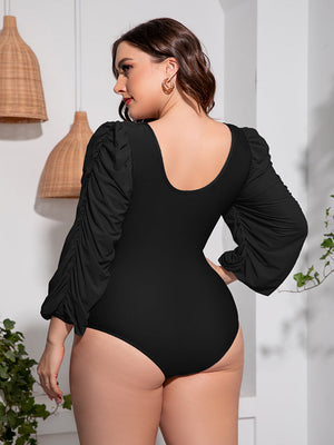 Black one-piece swimsuit with ruched balloon sleeves and a scoop neckline.