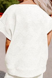 White textured knit tee with short sleeves and a geometric pattern.