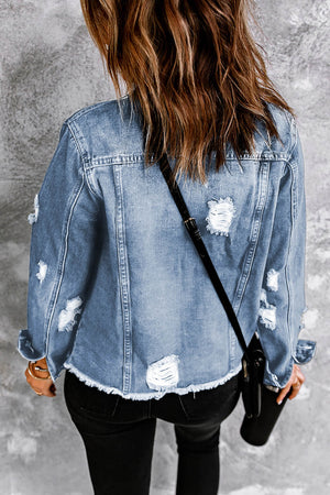 Blue distressed denim trucker jacket with frayed hem and ripped details.