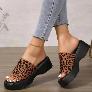 Platform knit slide sandals with leopard print and black sole.