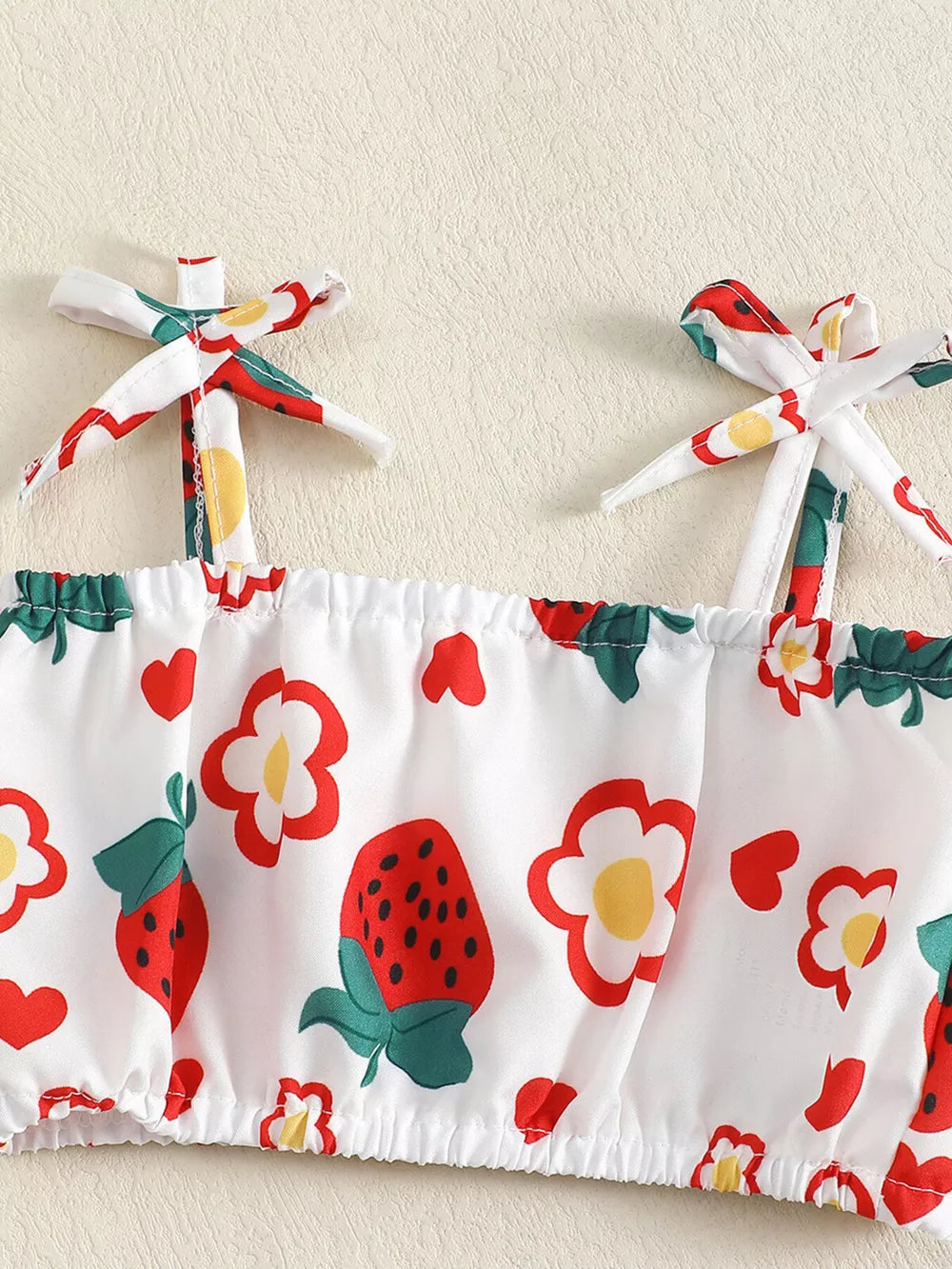 Baby set with strawberry and flower print, featuring tie straps and smocked hem.