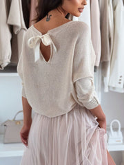 Cream knit sweater with batwing sleeves and a bow-back cutout detail