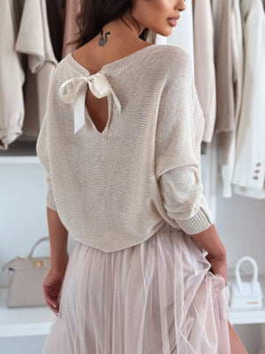 Cream knit sweater with batwing sleeves and a bow-back cutout detail