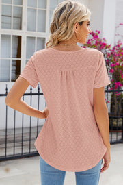 Blush pink eyelet yoke gathered henley shirt with short sleeves and a curved hem.