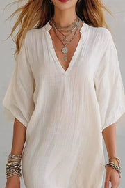 Relaxed white V-neck mini dress with half sleeves and airy linen-like fabric.
