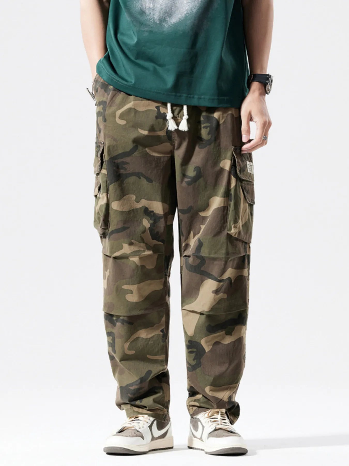 Casual cargo pants in camouflage pattern with drawstring waist and multiple pockets.