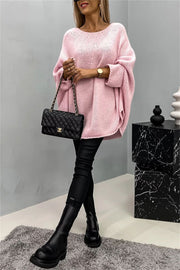 Blush pink relaxed knit sweater with cape sleeves and a round neckline.