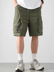 Green cargo shorts with multiple pockets and mesh detail.