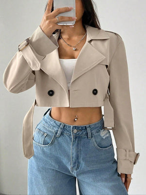 Beige cropped double-breasted trench coat with belt and adjustable cuffs.