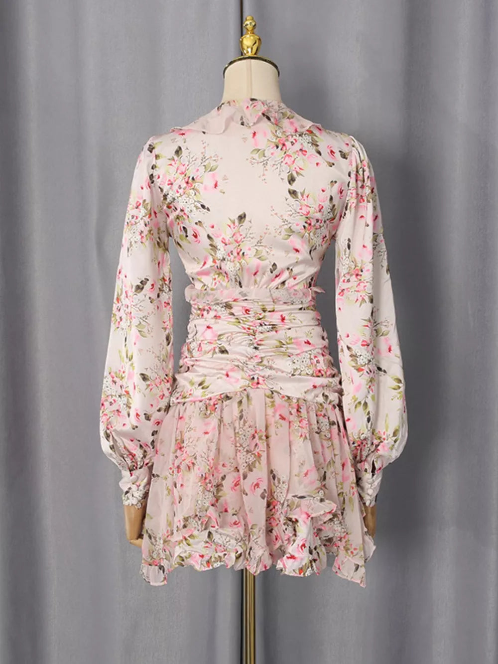 Charming ruffled floral mini dress with ruched waist and buttoned cuffs.