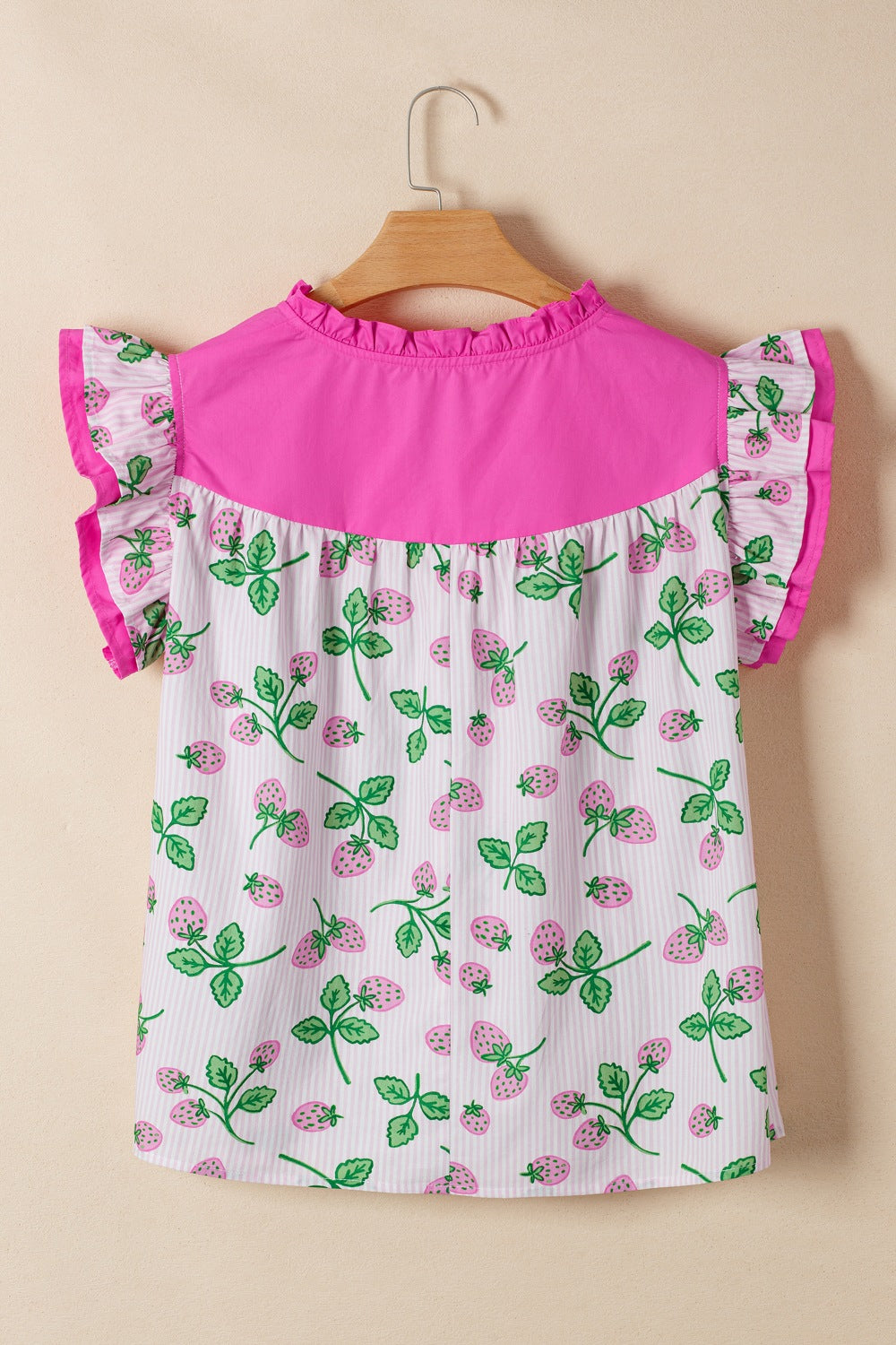 Strawberry print cotton blend blouse with pink color block yoke and flutter sleeves.