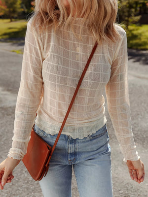 Sheer plaid long-sleeve top in beige with lettuce hem cuffs, styled with jeans.