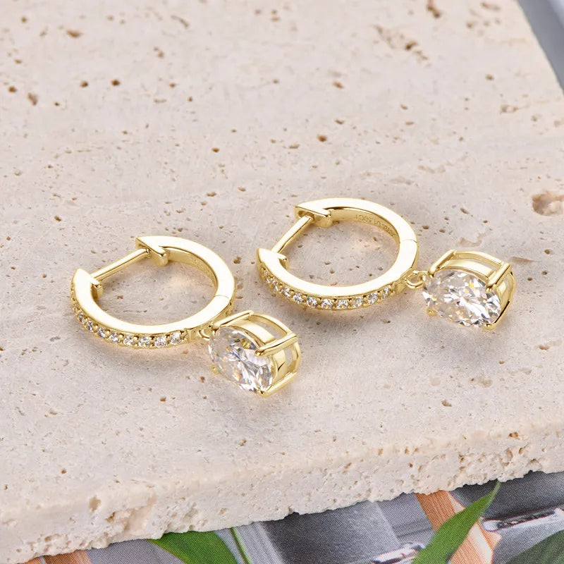 Gold pavé hoop and oval moissanite drop earrings with clear stones.