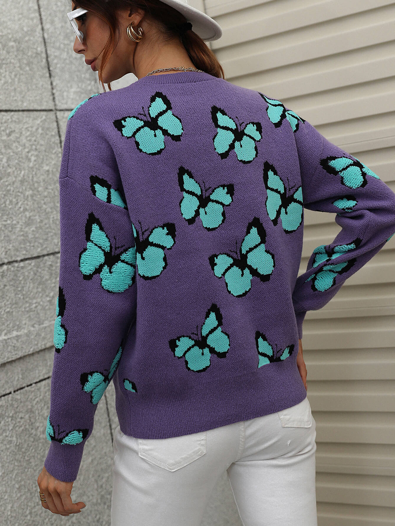 Purple knit crewneck sweater with allover teal butterfly motif