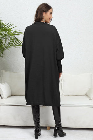 Black oversized pocketed knit cardigan with long sleeves and a relaxed fit.
