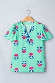 Mint green embroidered floral V-neck flutter sleeve blouse with blue leaf trim.
