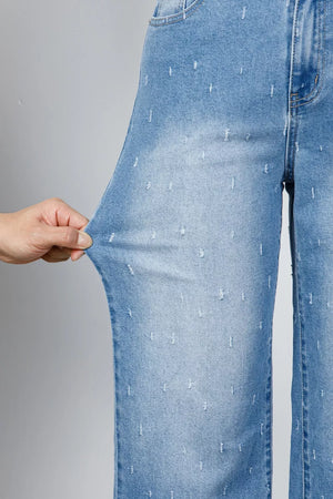 Light wash denim jeans with allover distressed details and a raw hem.