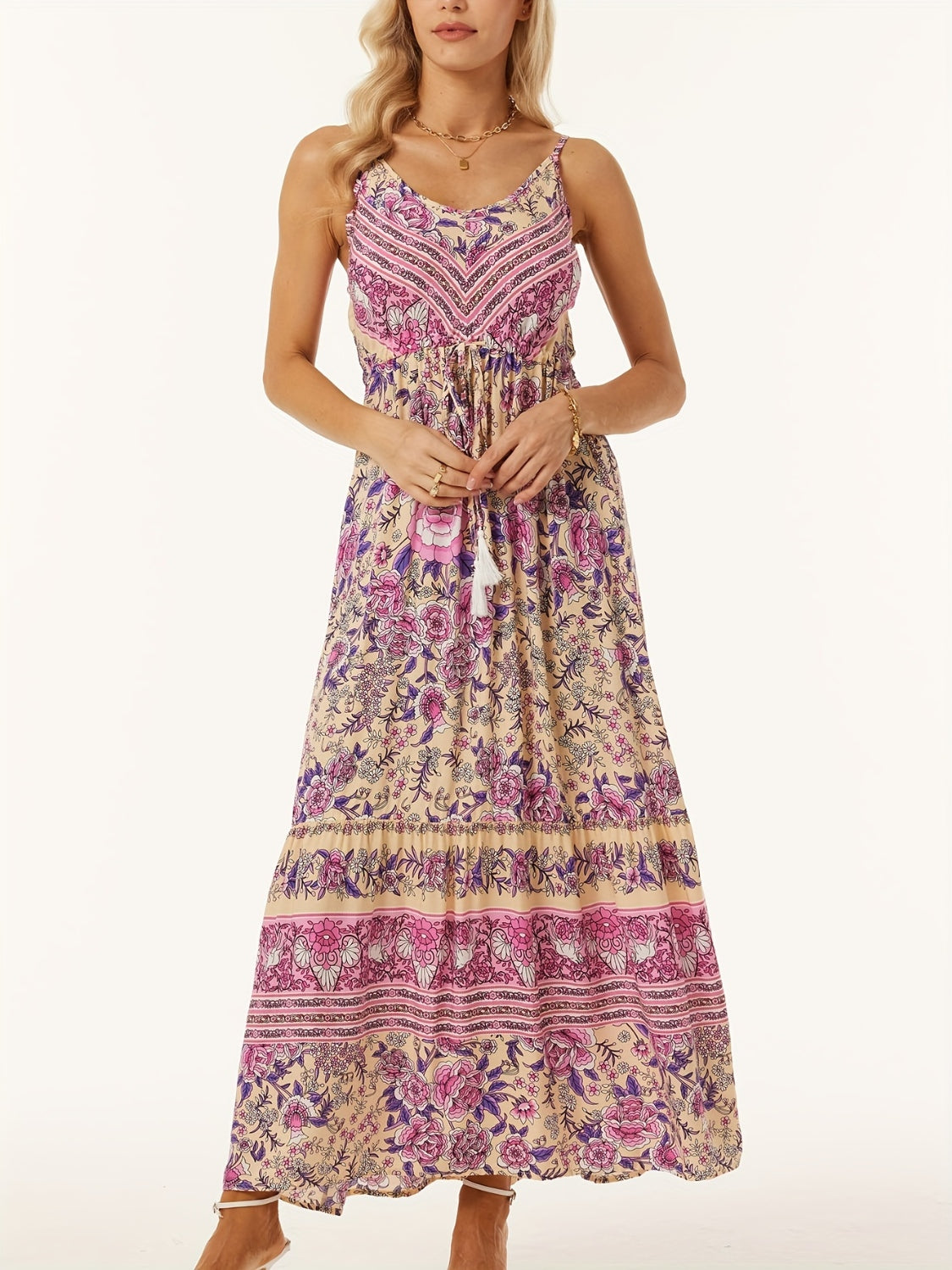 Bohemian maxi dress with adjustable waist, floral print, pink and purple details, and tassel tie.