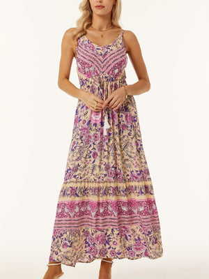 Bohemian maxi dress with adjustable waist, floral print, pink and purple details, and tassel tie.