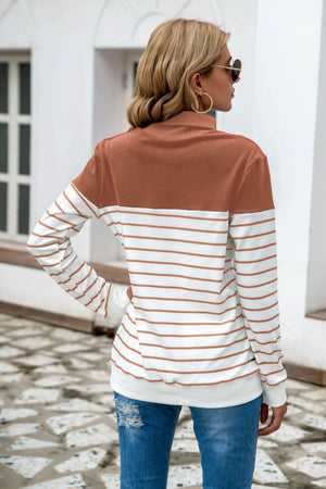Colorblock stripe turtleneck knit sweater with brown yoke and white sleeves.