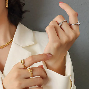 Sterling silver rings with knot detail, one gold, one silver.