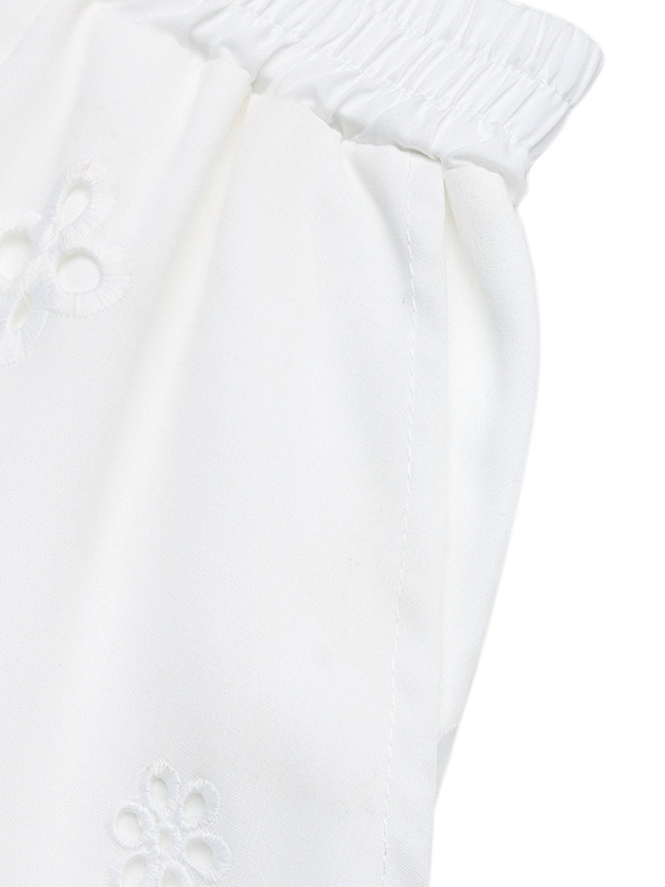 White embroidered lace trim pocketed shorts with elastic waistband.