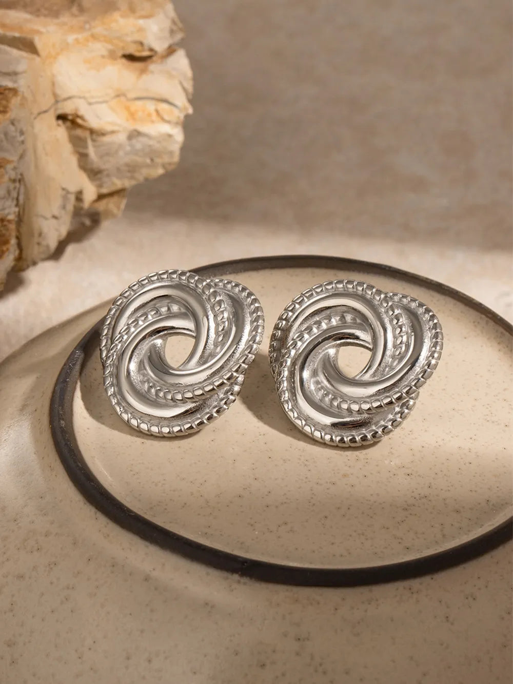 Silver swirl knot stud earrings with textured border