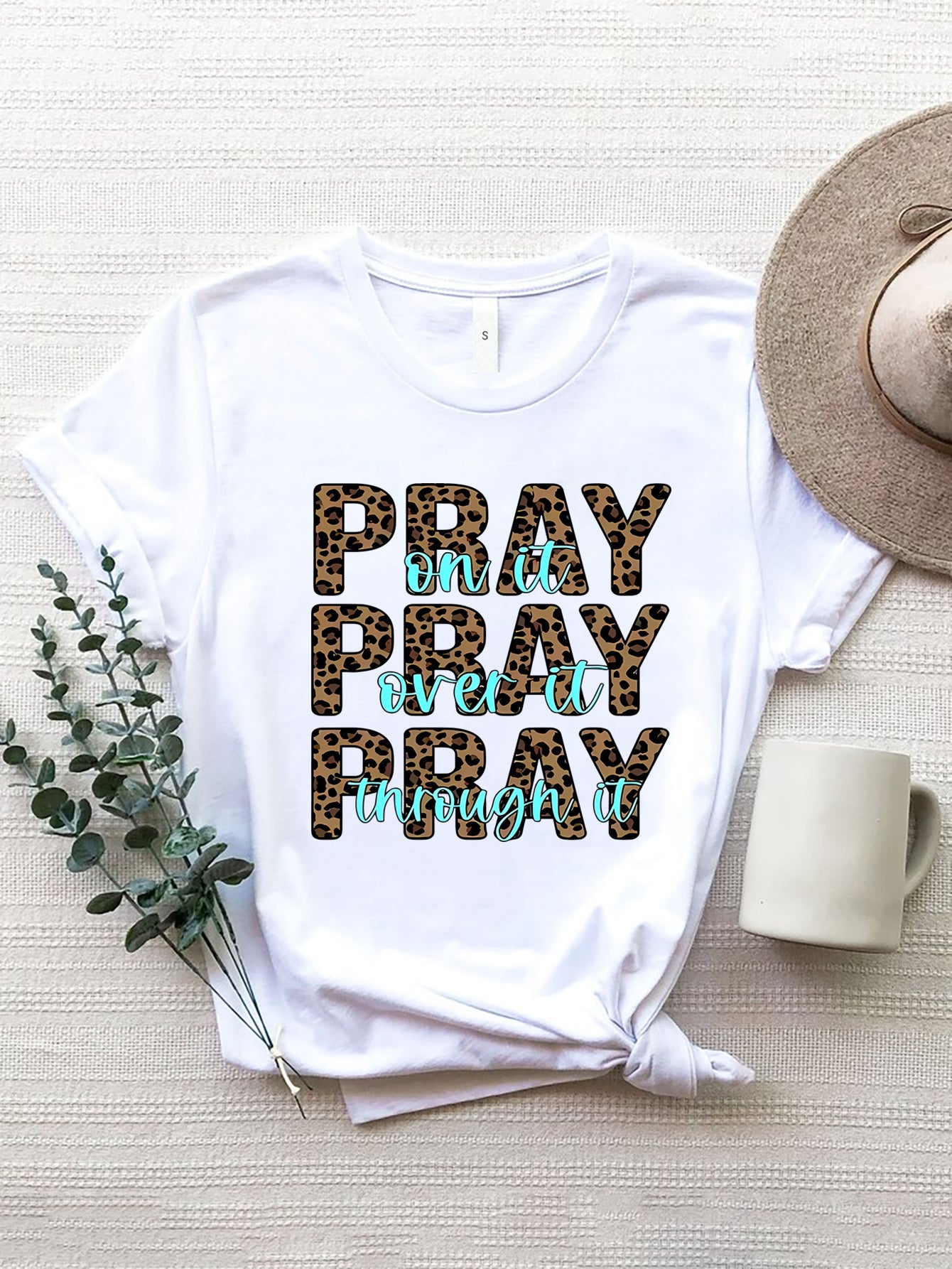 White graphic tee with leopard print text saying Pray on it, Pray over it, Pray through it.